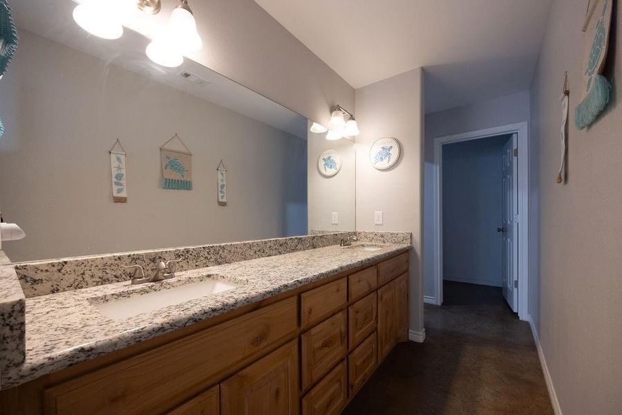 Full bathroom featuring double vanity and baseboards