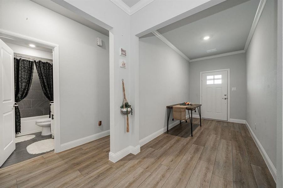 Foyer with light wood-style floors, ornamental molding, and recessed lighting Foyer with light wood-style floors, ornamental molding, and recessed lighting