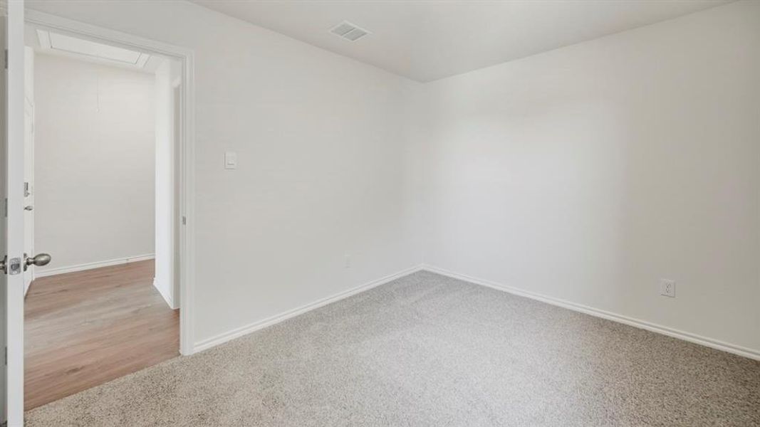 Spare room featuring light carpet and baseboards