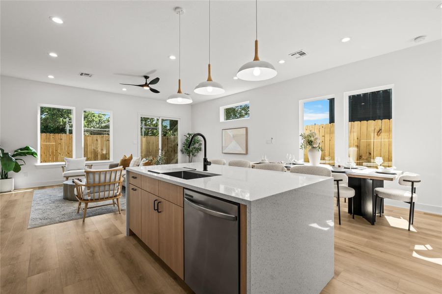 From the kitchen island, you can see how the whole main floor connects. It opens up to a bright dining area on the right and the living room straight ahead. Multiple large windows and the glass back door bring in plenty of natural light throughout the entire space.
