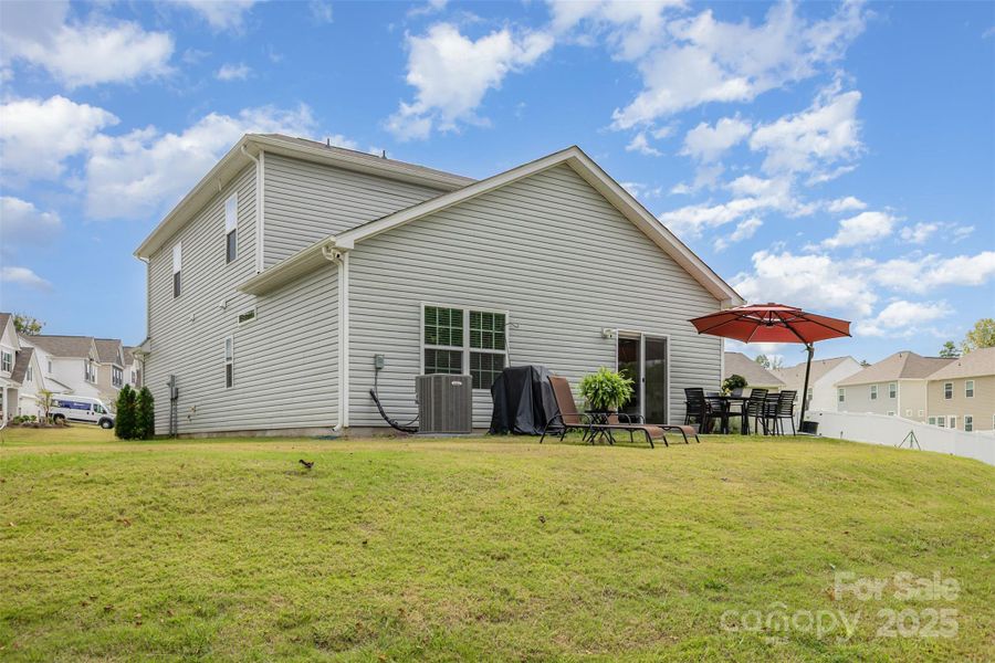 Large back yard with trees in the background