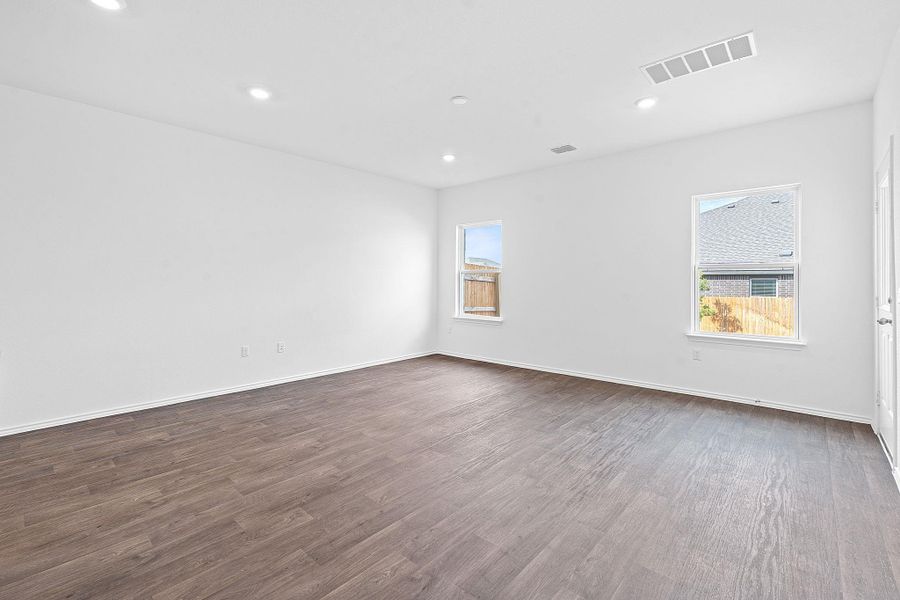 Spare room featuring dark wood-style flooring, healthy amount of natural light, and recessed lighting Spare room featuring dark wood-style flooring, healthy amount of natural light, and recessed lighting