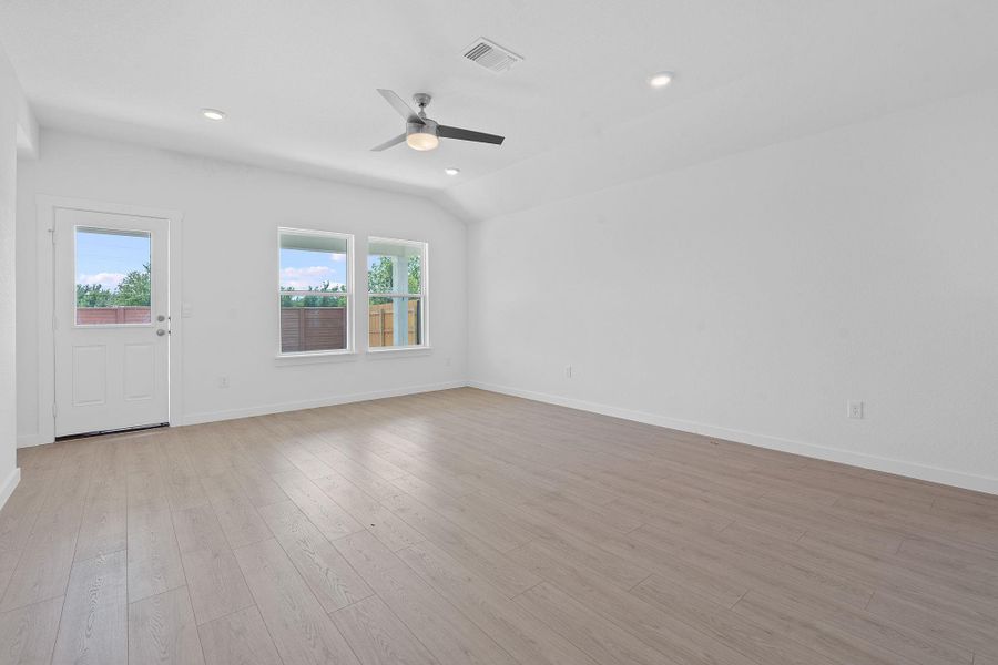 Unfurnished living room with light wood-style flooring, recessed lighting, lofted ceiling, and ceiling fan Unfurnished living room with light wood-style flooring, recessed lighting, lofted ceiling, and ceiling fan