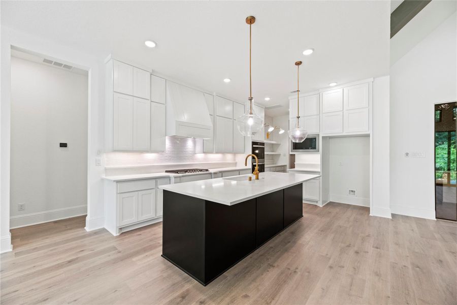 Quartz countertops, stainless steel appliances, floor-to-ceiling custom cabinetry, and elegant pendant lighting, crafted for both entertaining and everyday living.