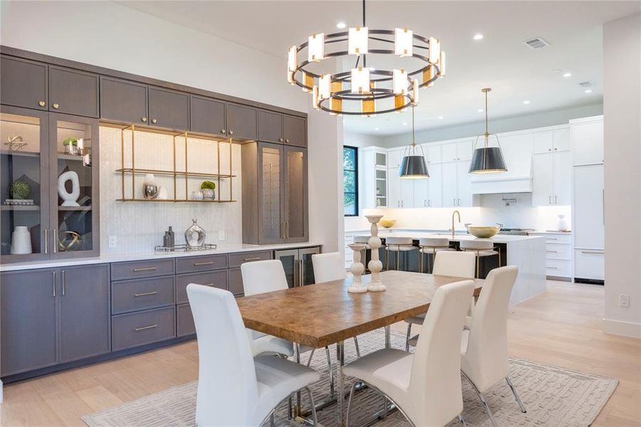 Dining space featuring sink, a chandelier, and light wood-type flooring