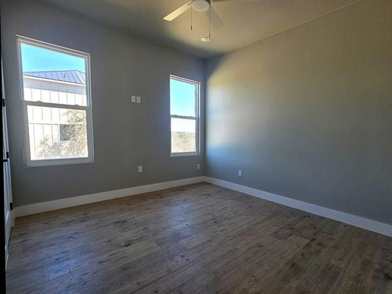 Unfurnished room with dark wood-type flooring and a ceiling fan