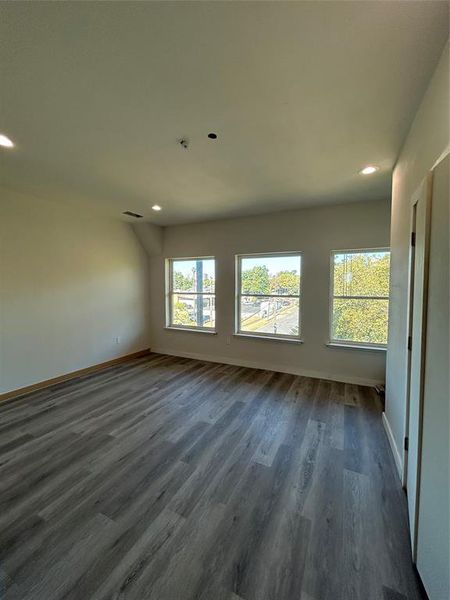 Spare room with recessed lighting, dark wood finished floors, and healthy amount of natural light