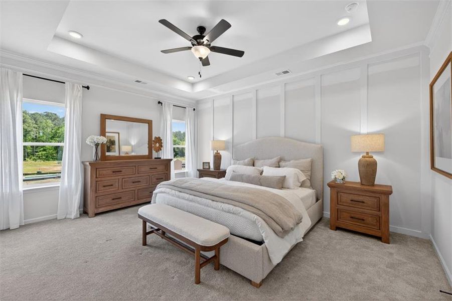 Carpeted room featuring a tray ceiling with recessed lighting, crown molding, and a ceiling fan