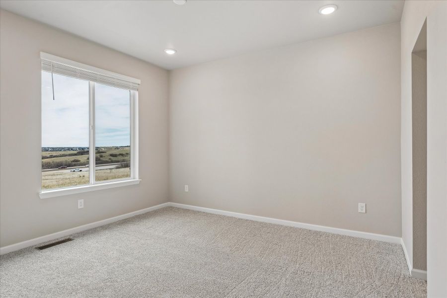 A room with a window and a carpet.