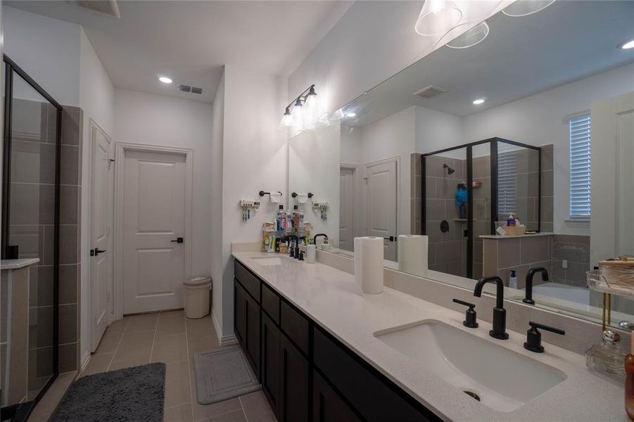 Dual vanity with integrated sinks and black fixtures, featuring a large mirror and contemporary light fixture
