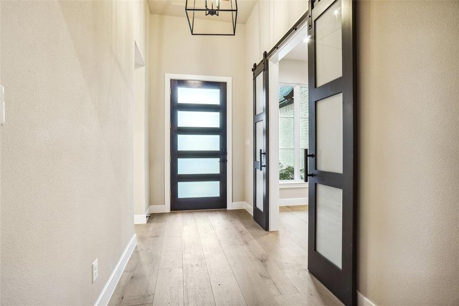 Foyer has beautiful boxed ceiling with stained slat wood and large iron chandelier. Custom sliding doors to the home office add drama to the foyer! Foyer has beautiful boxed ceiling with stained slat wood and large iron chandelier. Custom sliding doors to the home office add drama to the foyer!