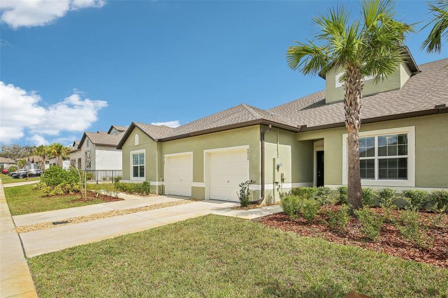 Front exterior of a new home in Abbott Square: The Villas, Zephyrhills, FL, highlighting curb appeal (Image 22). Front exterior of a new home in Abbott Square: The Villas, Zephyrhills, FL, highlighting curb appeal (Image 22).