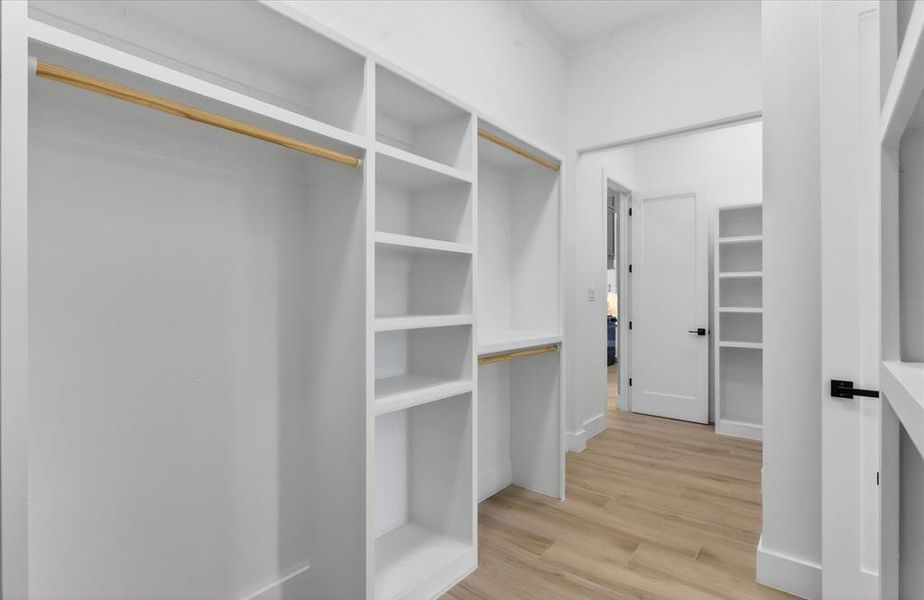 Custom built-in closet system featuring multiple hanging rods and shelving