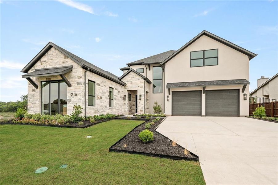 View of front of home with a garage and a front yard