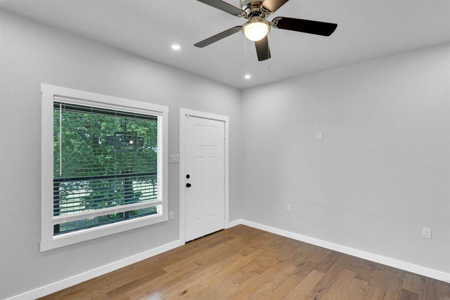 Upstairs Bedroom with access to second level balcony and wood finished floors, baseboards, ceiling fan, and recessed lighting