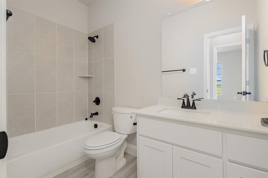 Bathroom with vanity, shower / tub combination, and wood finished floors