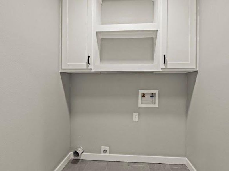 Laundry area featuring cabinet space, hookup for a washing machine, and wood finished floors