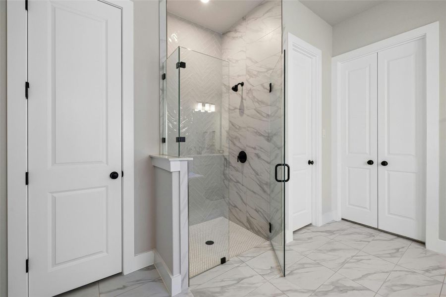 Full bath with marble finish flooring and a marble finish shower Full bath with marble finish flooring and a marble finish shower