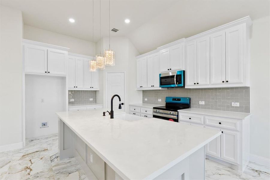 Kitchen featuring stainless steel appliances, a sink, visible vents, white cabinetry, and marble finish floor Kitchen featuring stainless steel appliances, a sink, visible vents, white cabinetry, and marble finish floor
