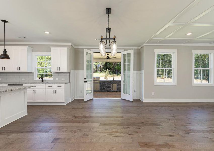 Dining area with French doors that open to the covered back patio with a grill.