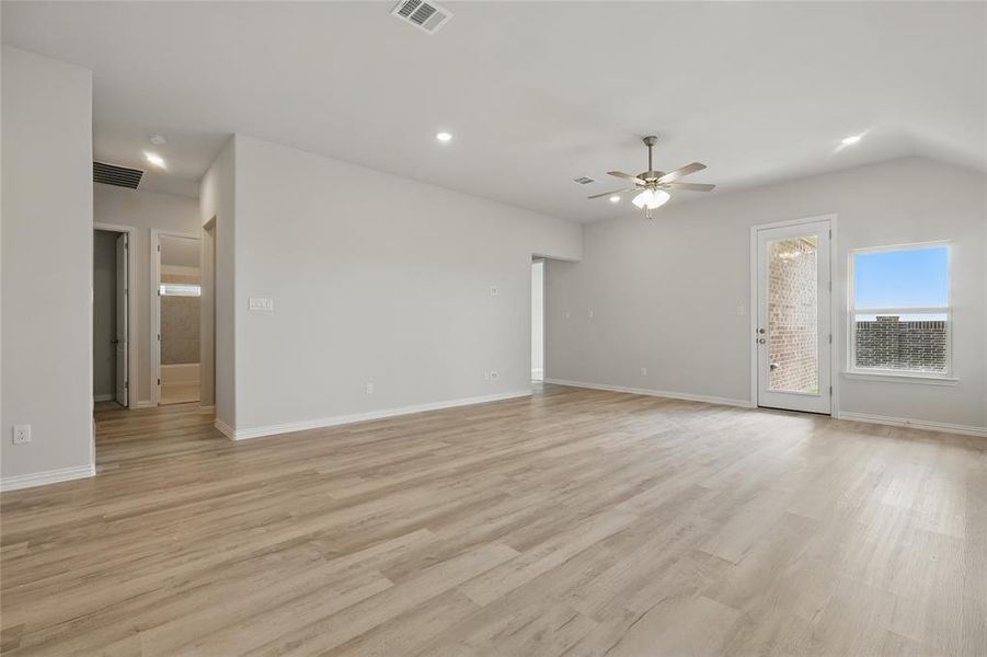 Unfurnished living room featuring a ceiling fan, light wood finished floors, baseboards, recessed lighting, and lofted ceiling