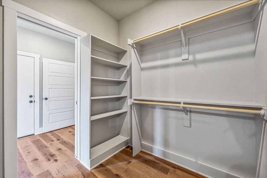 Walk in closet featuring light wood-type flooring Walk in closet featuring light wood-type flooring
