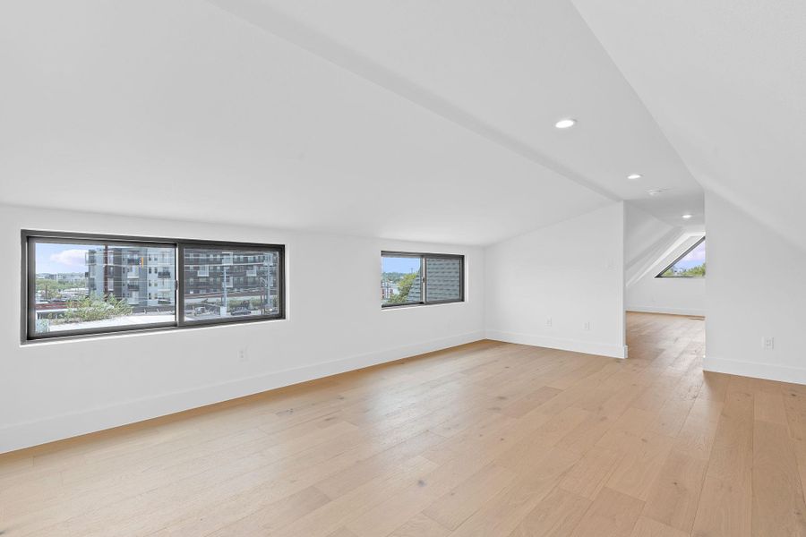 Bonus room featuring recessed lighting, light wood-style flooring, baseboards, and vaulted ceiling