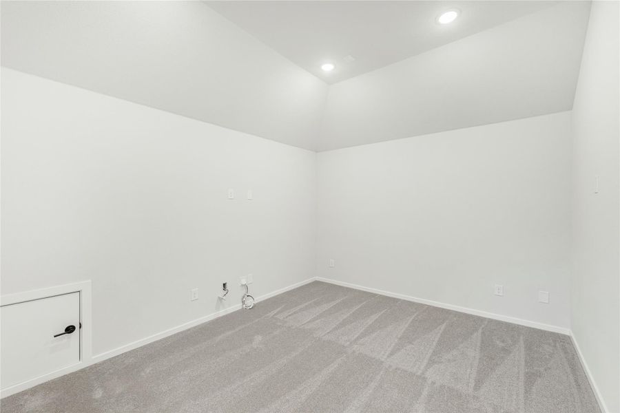 Empty room with white walls, gray carpet, recessed lighting, and a small white cabinet in the corner Empty room with white walls, gray carpet, recessed lighting, and a small white cabinet in the corner