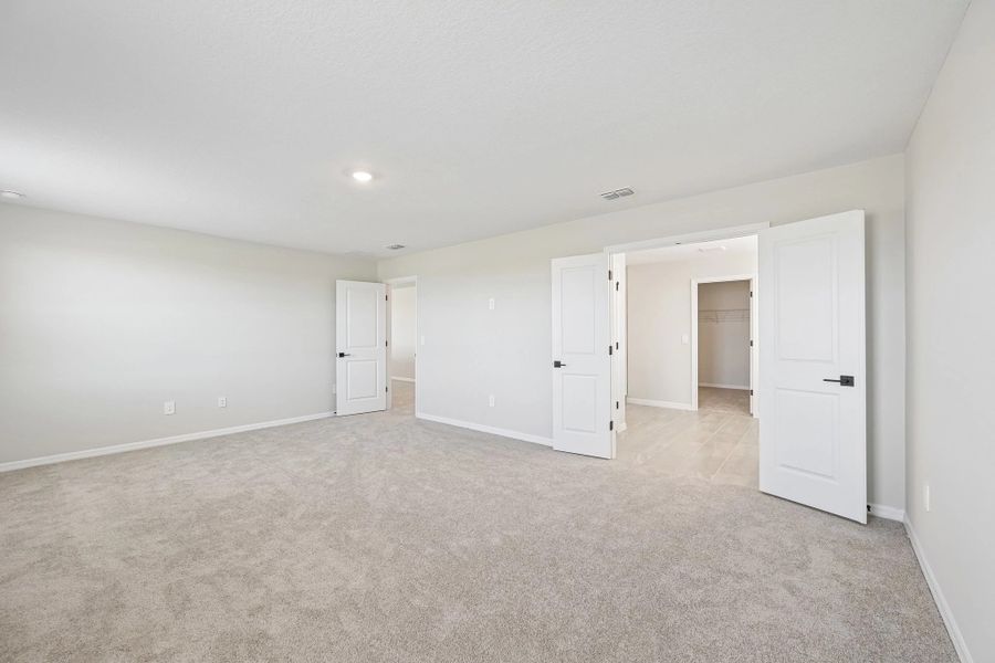 The primary bedroom opens up into the primary bathroom with double doors