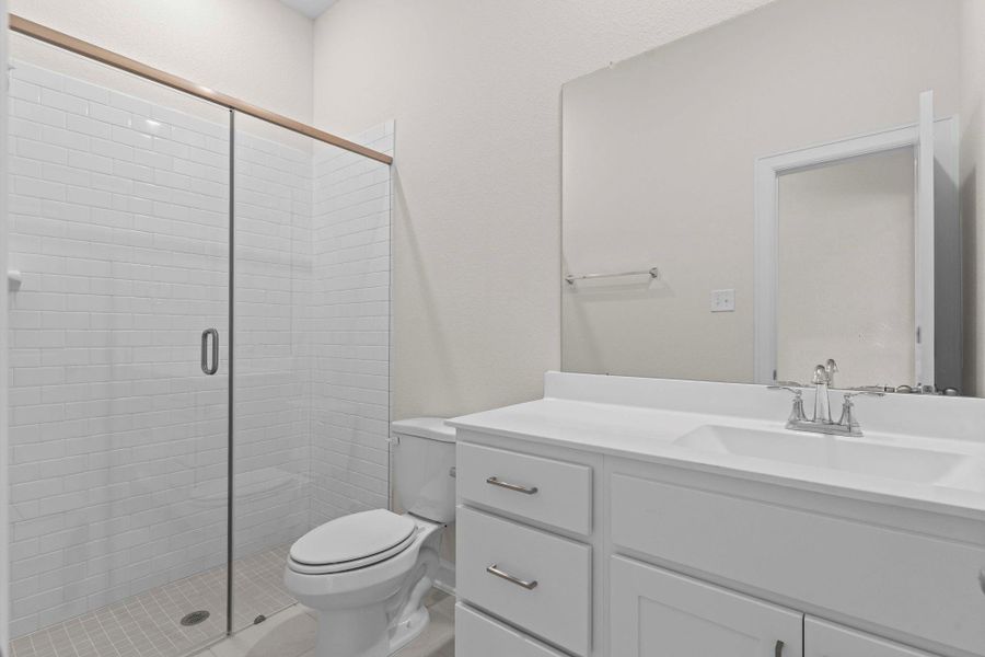 Elegant full bathroom with sleek tile shower, white vanity with ample storage, and modern fixtures.  All the bathrooms have Elongated water saver commodes and no cheap plastic shower pans, but Mud Shower pans.