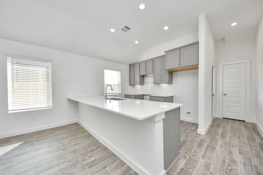 The kitchen is a culinary haven, featuring granite countertops, a tile backsplash, stainless steel appliances, 42” upper cabinets, and undercabinet lighting.