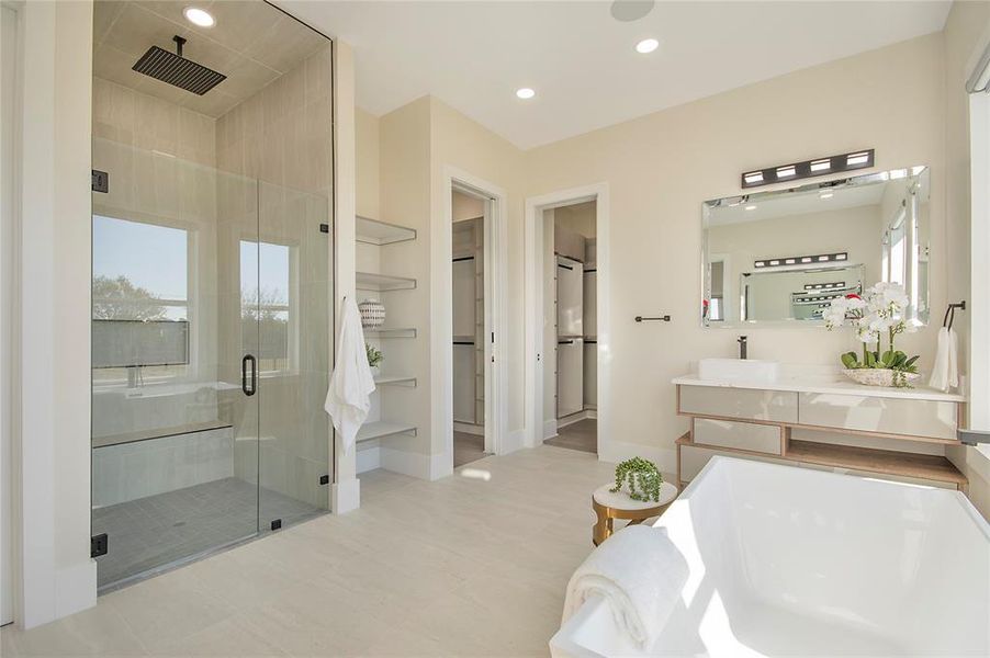 Bathroom featuring vanity, a spacious closet, a shower stall, a bathtub, and recessed lighting Bathroom featuring vanity, a spacious closet, a shower stall, a bathtub, and recessed lighting