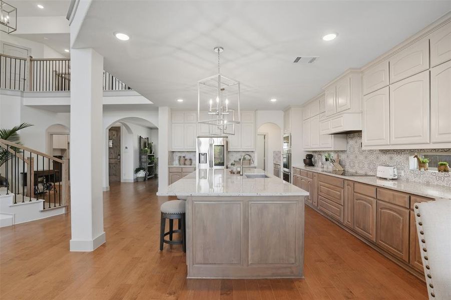 Kitchen featuring arched walkways, a chandelier, decorative light fixtures, dark wood-style floors, and recessed lighting Kitchen featuring arched walkways, a chandelier, decorative light fixtures, dark wood-style floors, and recessed lighting
