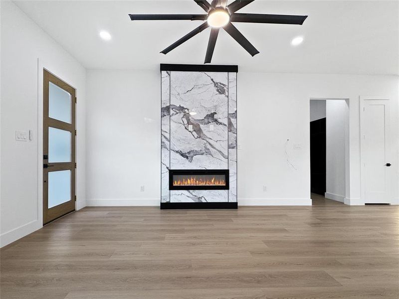 Unfurnished living room with light wood-style floors, a fireplace, recessed lighting, and ceiling fan
