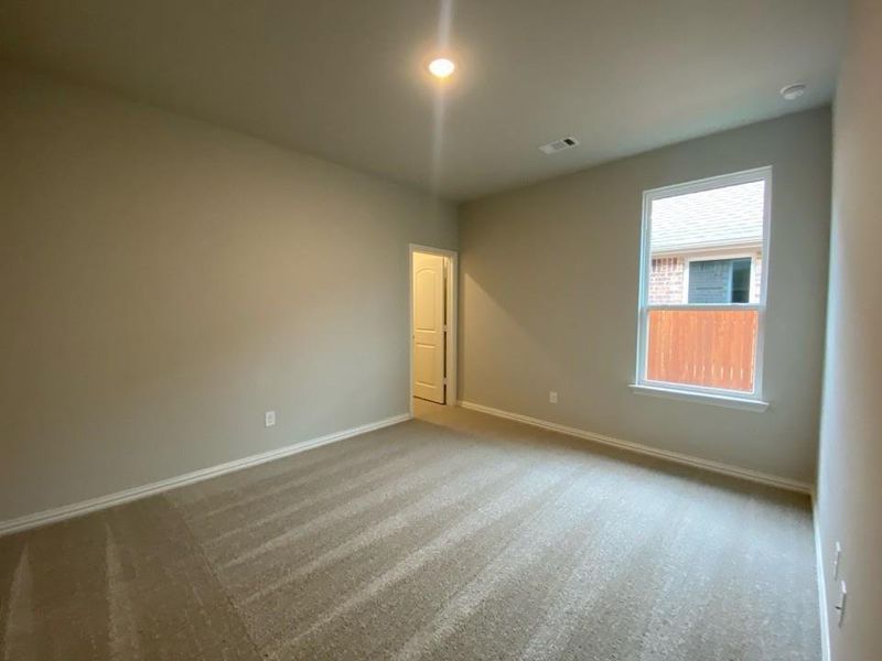 Carpeted room with neutral wall tones, white baseboards, and a single window Carpeted room with neutral wall tones, white baseboards, and a single window