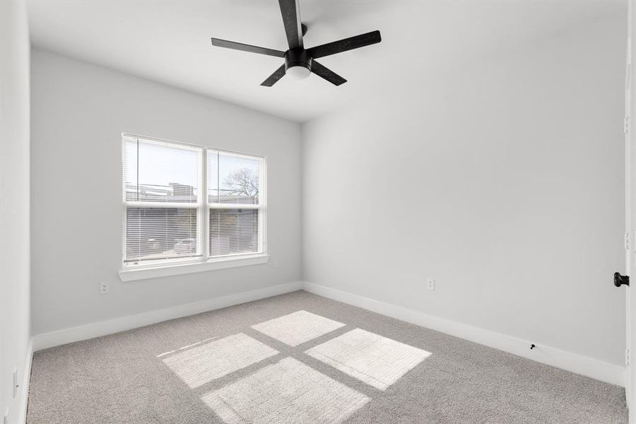 Unfurnished room featuring light carpet, ceiling fan, and baseboards