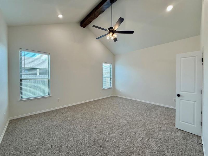 Carpeted empty room with beamed ceiling, ceiling fan, and high vaulted ceiling