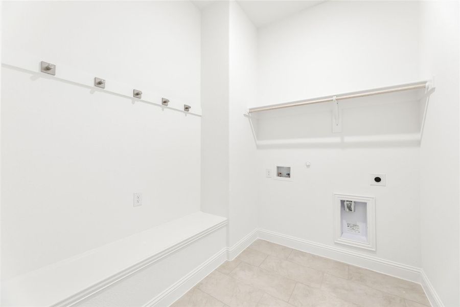 Mudroom with built-in bench, wall hooks, upper shelf, and washer-dryer hookups on tile floor Mudroom with built-in bench, wall hooks, upper shelf, and washer-dryer hookups on tile floor