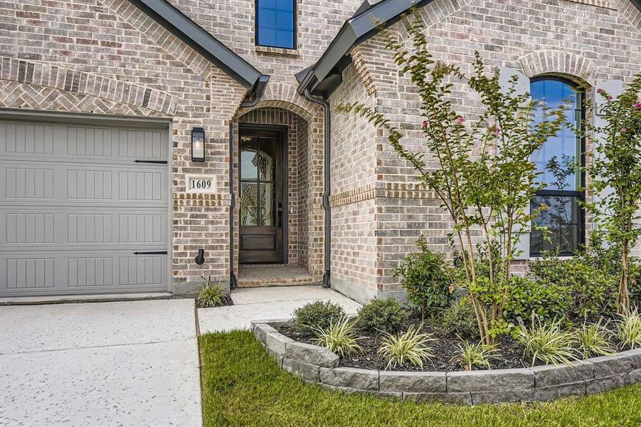 Property entrance with brick siding and a garage Property entrance with brick siding and a garage