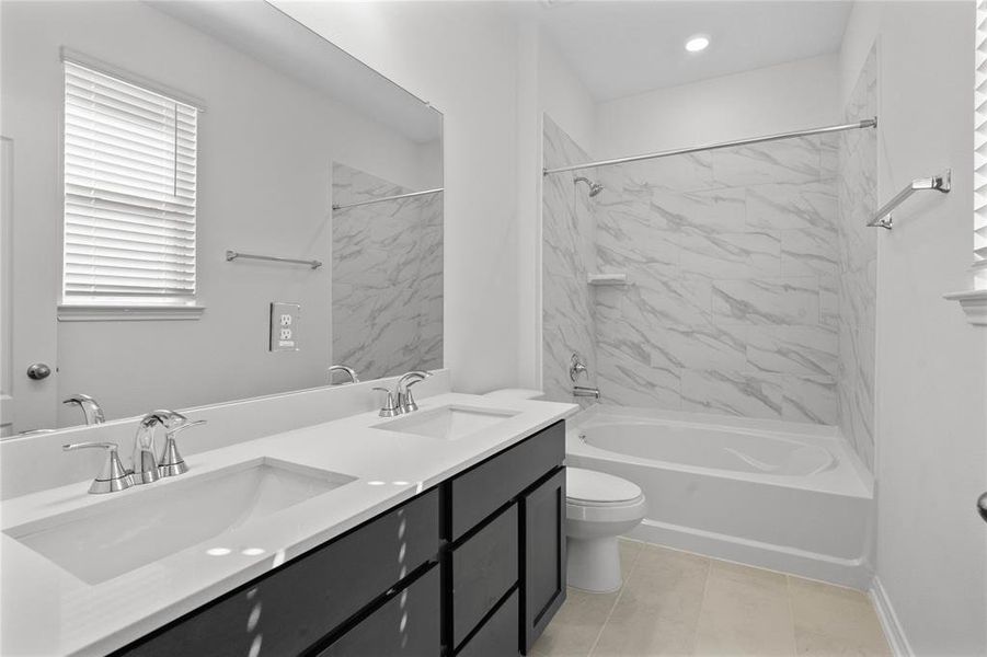 This primary bathroom is definitely move-in ready! Featuring a tub/shower combo with tile surround, stained cabinets with light countertops, high ceilings, custom paint, sleek and modern finishes.