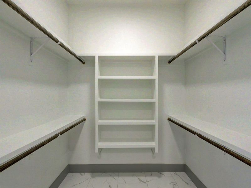 A customized walk-in closet boasts extensive built-in shelving, hanging rods, and polished tile flooring.