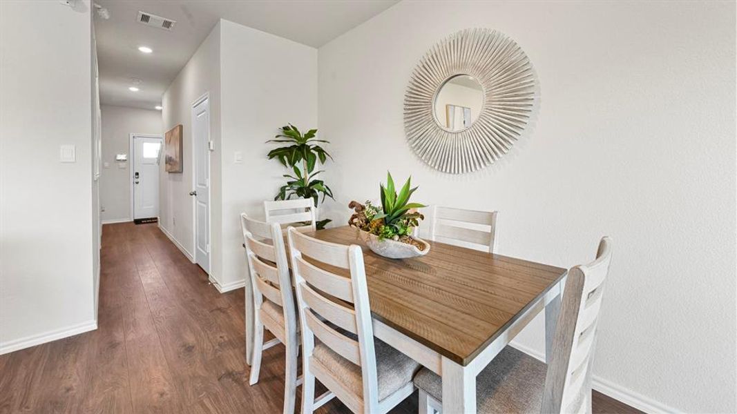 Dining area with dark wood-style floors and recessed lighting