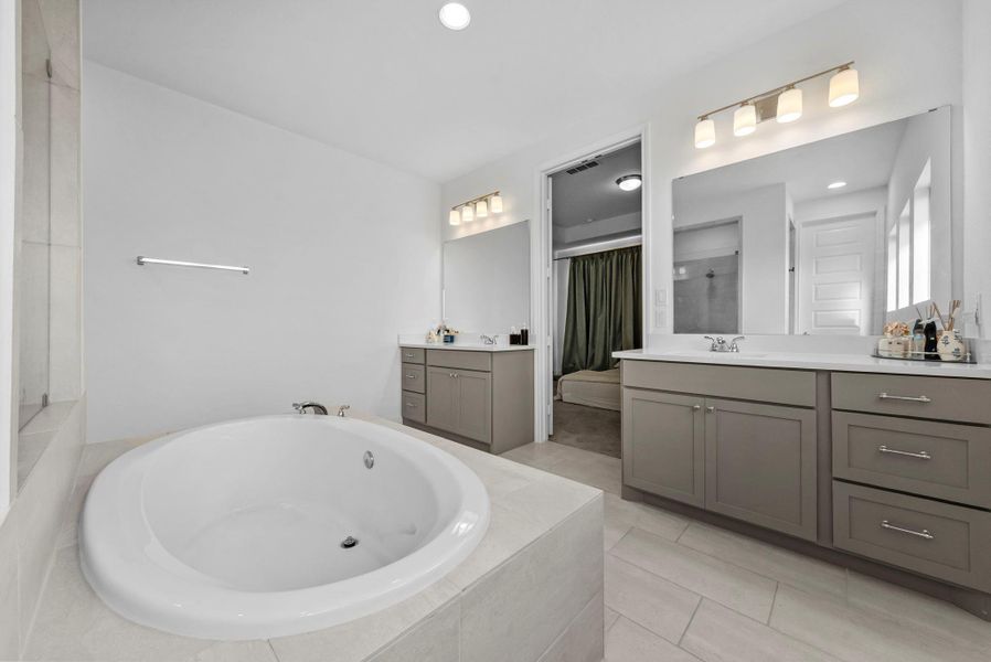 Bathroom with two vanities, a bath, a shower, light tile patterned flooring, and recessed lighting