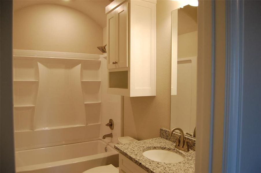 Full bathroom featuring washtub / shower combination, toilet, and vanity