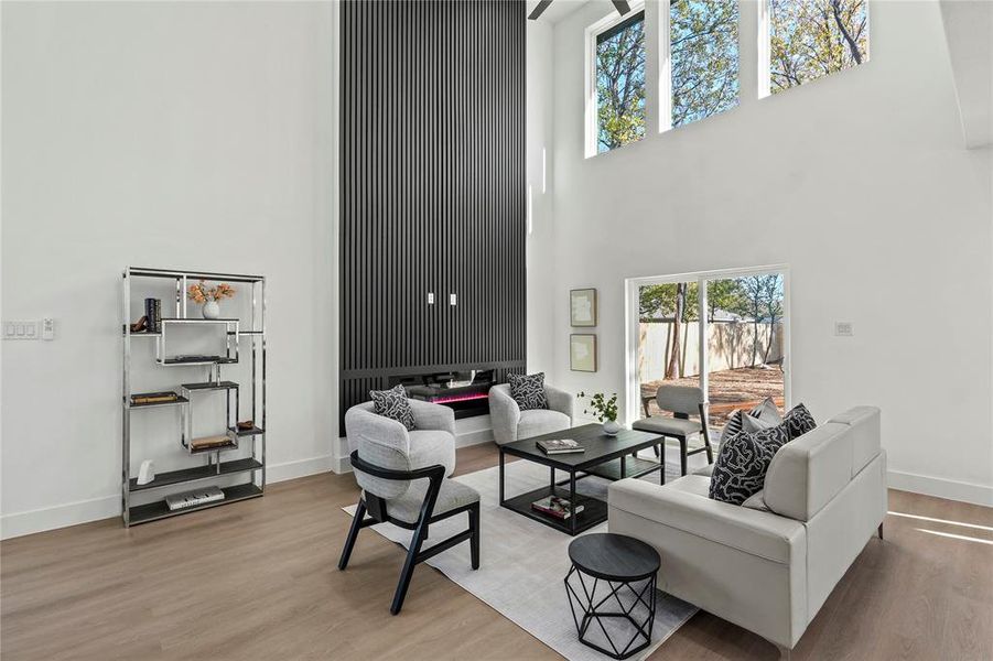 Living room featuring a high ceiling and light hardwood / wood-style floors