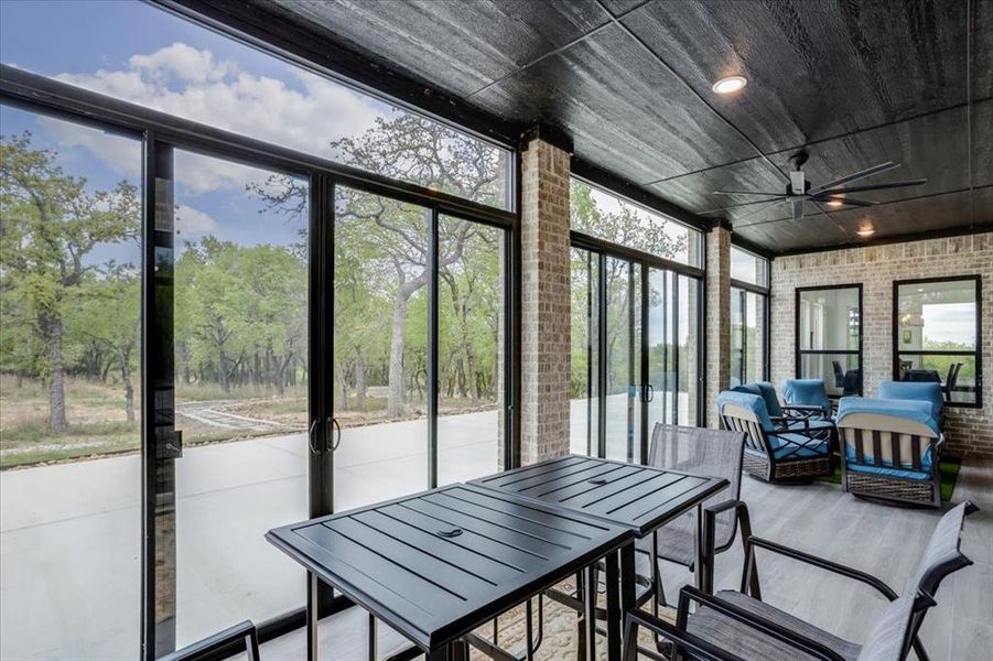 Sunroom featuring a ceiling fan, a patio area, and outdoor lounge area