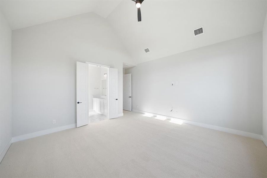 Unfurnished bedroom featuring high vaulted ceiling, light carpet, a ceiling fan, and ensuite bathroom Unfurnished bedroom featuring high vaulted ceiling, light carpet, a ceiling fan, and ensuite bathroom