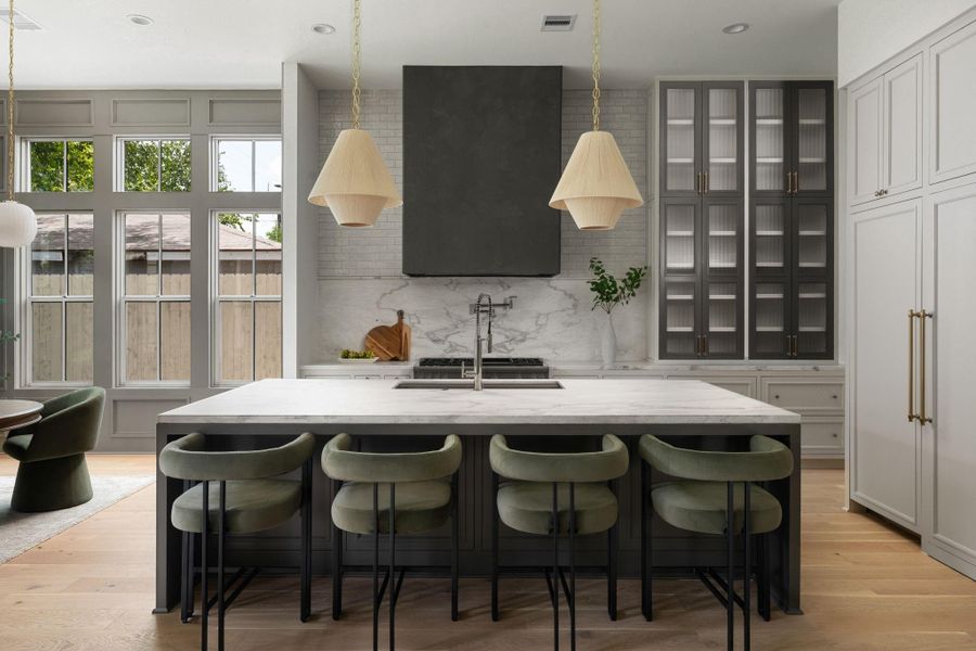 Thermador appliance package, natural quartzite countertops and splash, and a dramatic plaster finish vent hood make the kitchen both functional and breathtaking.