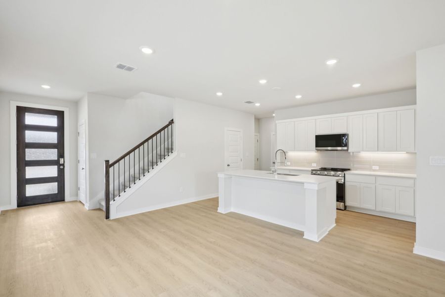 A kitchen with white cabinets.