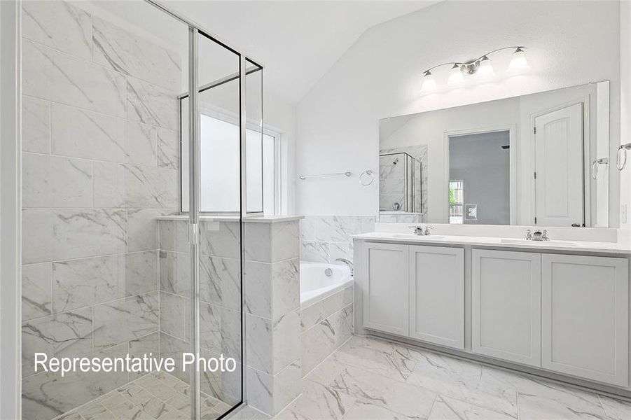 Spacious bathroom featuring a glass-enclosed shower with marble-look tile, a separate soaking tub, and a double vanity with ample counter space